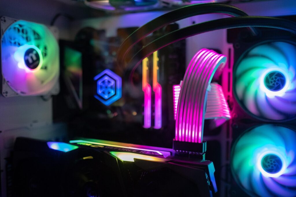 Close-up of a high-end gaming PC with RGB lighting, featuring illuminated cooling fans, a graphics card, and custom cable management.